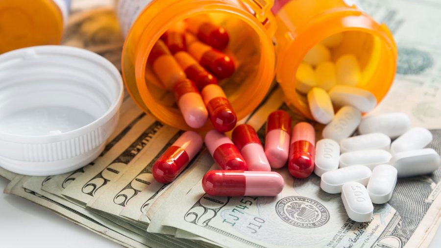 pile of 20 dollar bills and medicine containers on white background