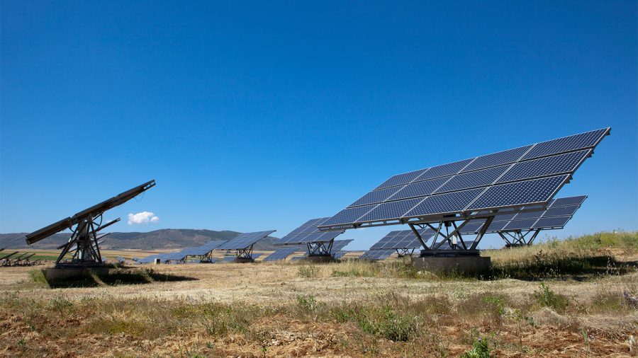 Photo of Solar photovoltaics panels field for renewable energy production with blue sky,