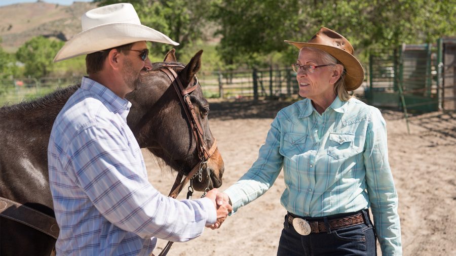 Photo of ranchers shaking hands and doing business on the ranch