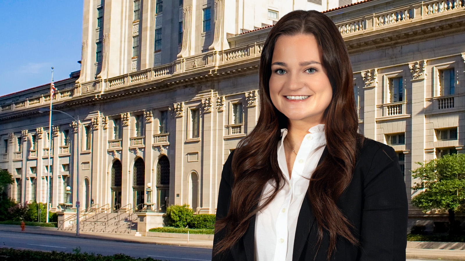 Photo of McAfee & Taft trial lawyer Caroline Rowland, with long brown hair wearing a black blazer and white shirt, positioned in front of the historic U.S. Post Office and Courthouse in downtown Oklahoma City.
